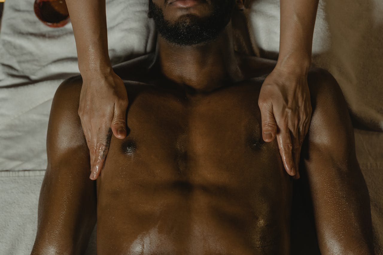 Hands providing a relaxing massage on a man's chest, promoting relaxation and wellness.